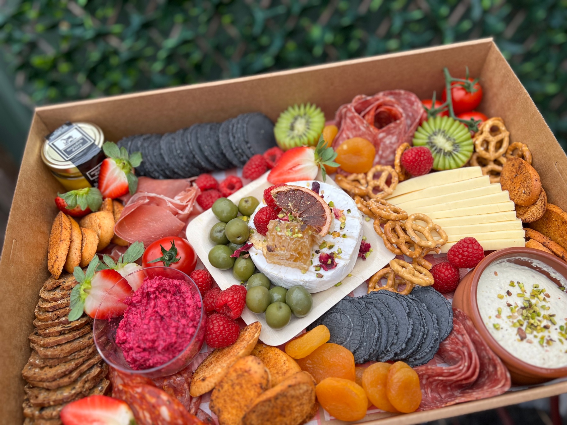 Charcuterie box with baked brie, olives and pretzels