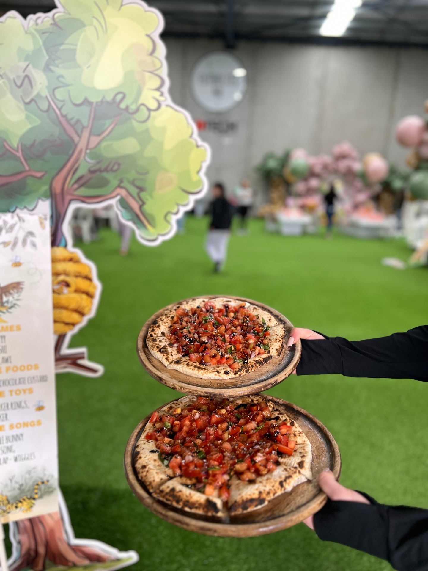Two bruschetta pizzas being served at an indoor event