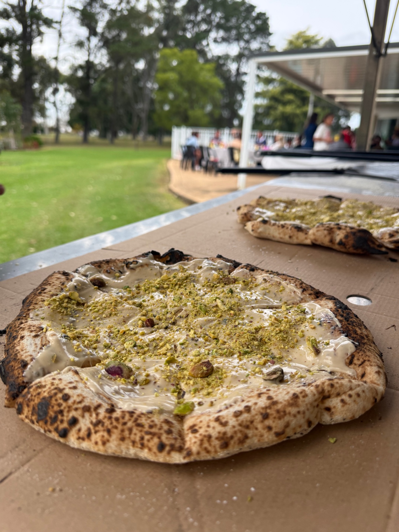Pistachio dessert pizza served outdoors
