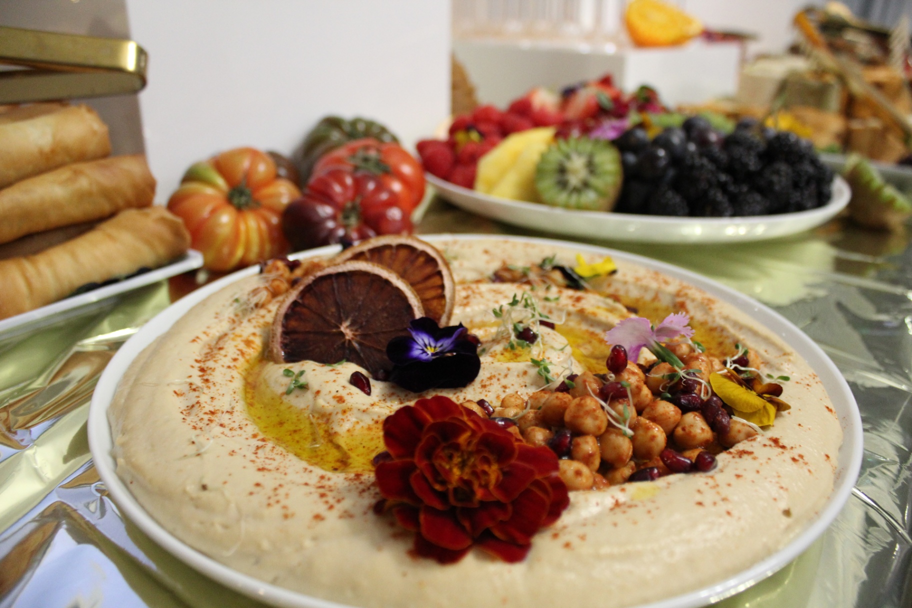 Hummus plate with chickpeas, edible flowers and heirloom tomatoes