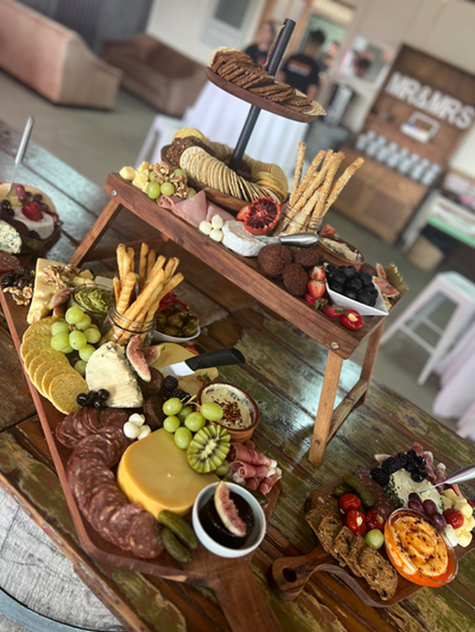 Elevated charcuterie stands with cheese, crackers and fruit