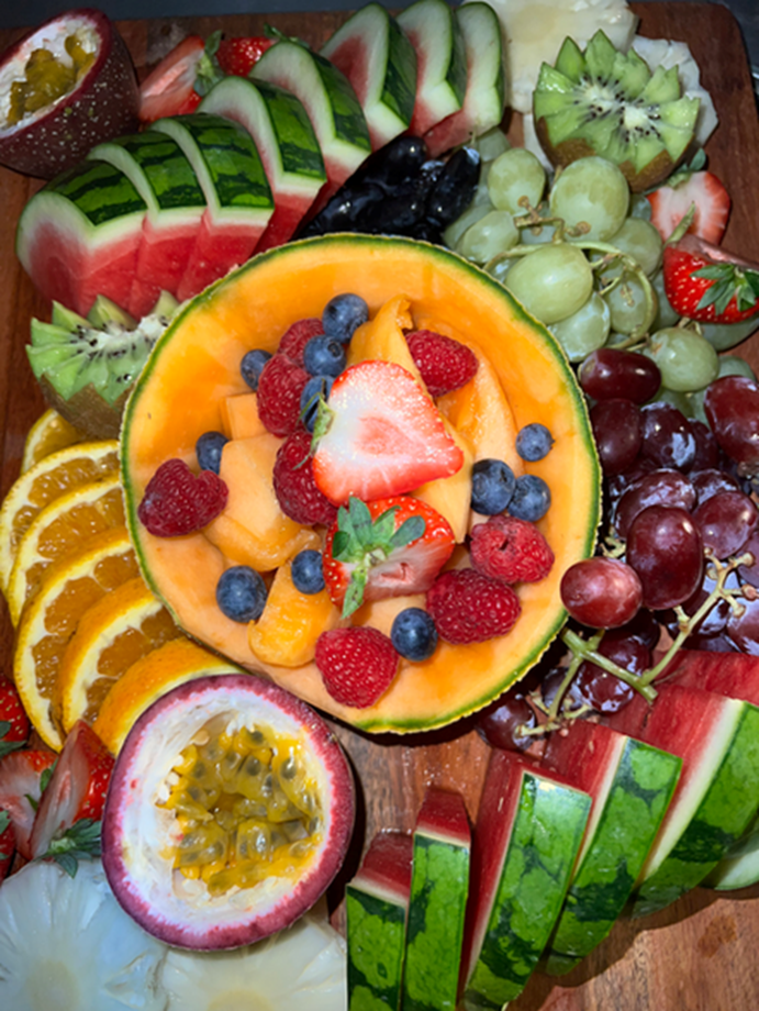 Close-up of a fruit platter with melon, berries, grapes and passionfruit