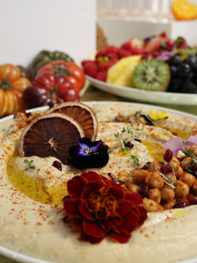 Hummus platter with garnishes, fruit and fresh produce