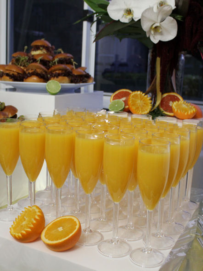 Orange welcome drinks with sliders and citrus styling