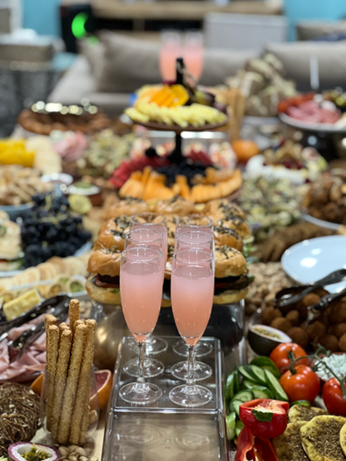 Full grazing table with pink drinks, fruit and savoury bites